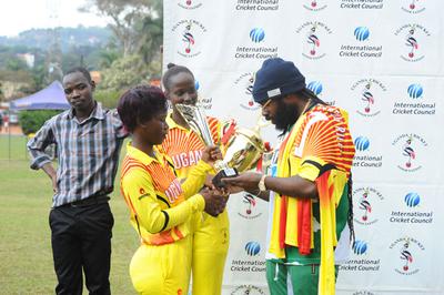 Jamaican Reggae star Riley (R) admires trophies presented to her by the Lady Cricket Cranes skipper Kevin Awino (L) and Janet Mbabazi (C) 